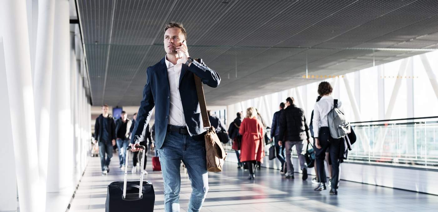 man walking through airport on phone
