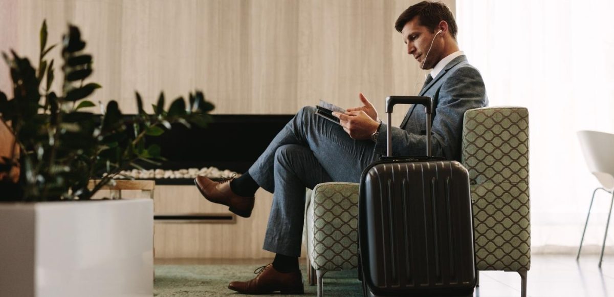 man sitting in armchair with suitcase