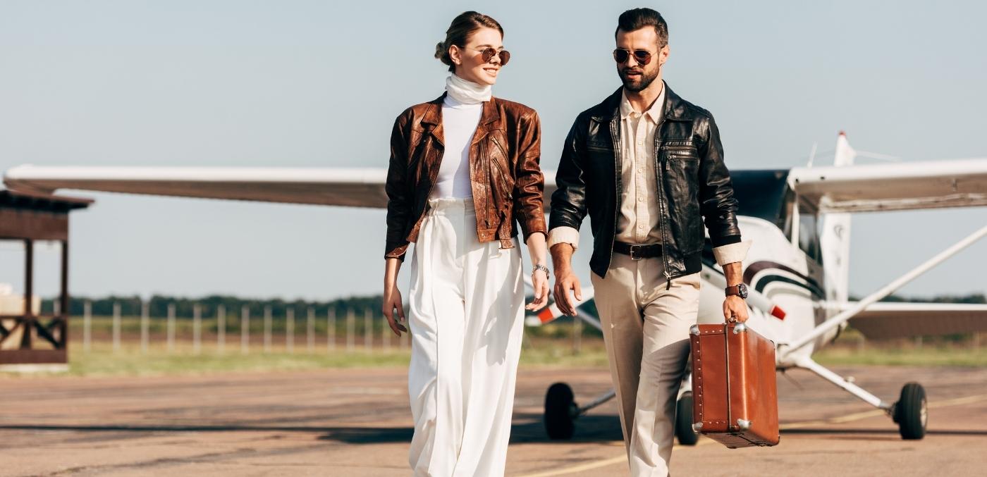 a stylish couple walking away from a plane