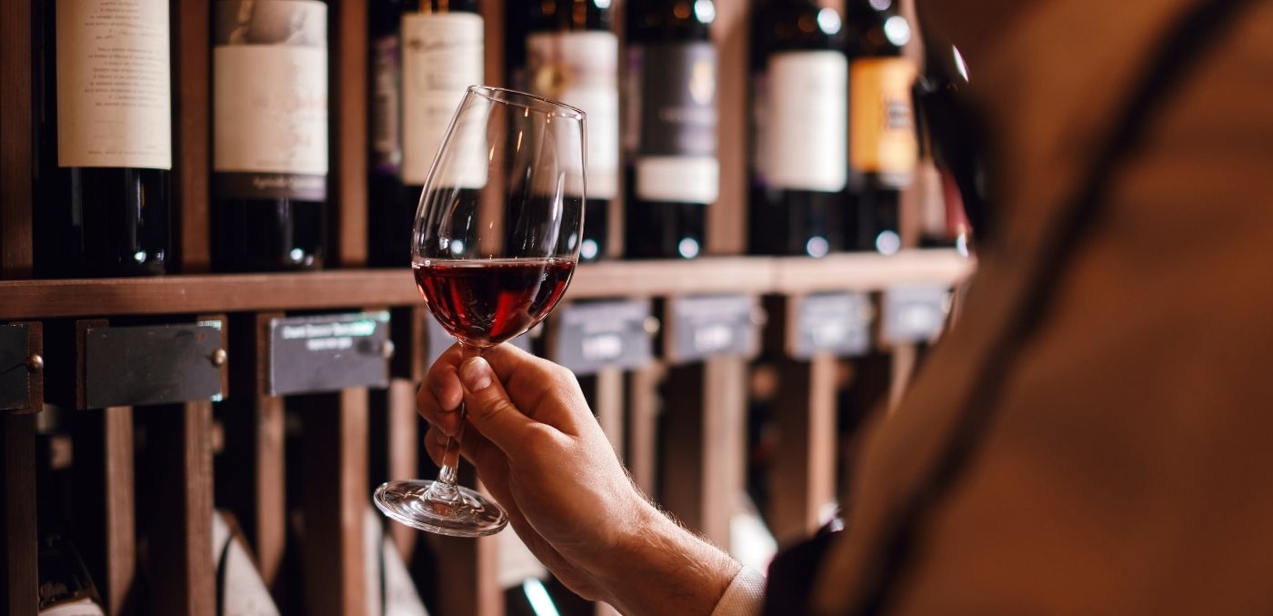 person holding a full wine glass for sampling