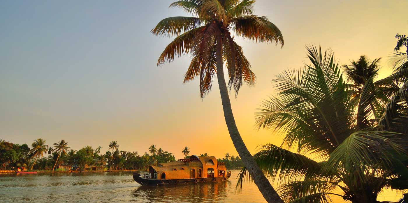 A boat sailing on Kerala backwaters during sunset.