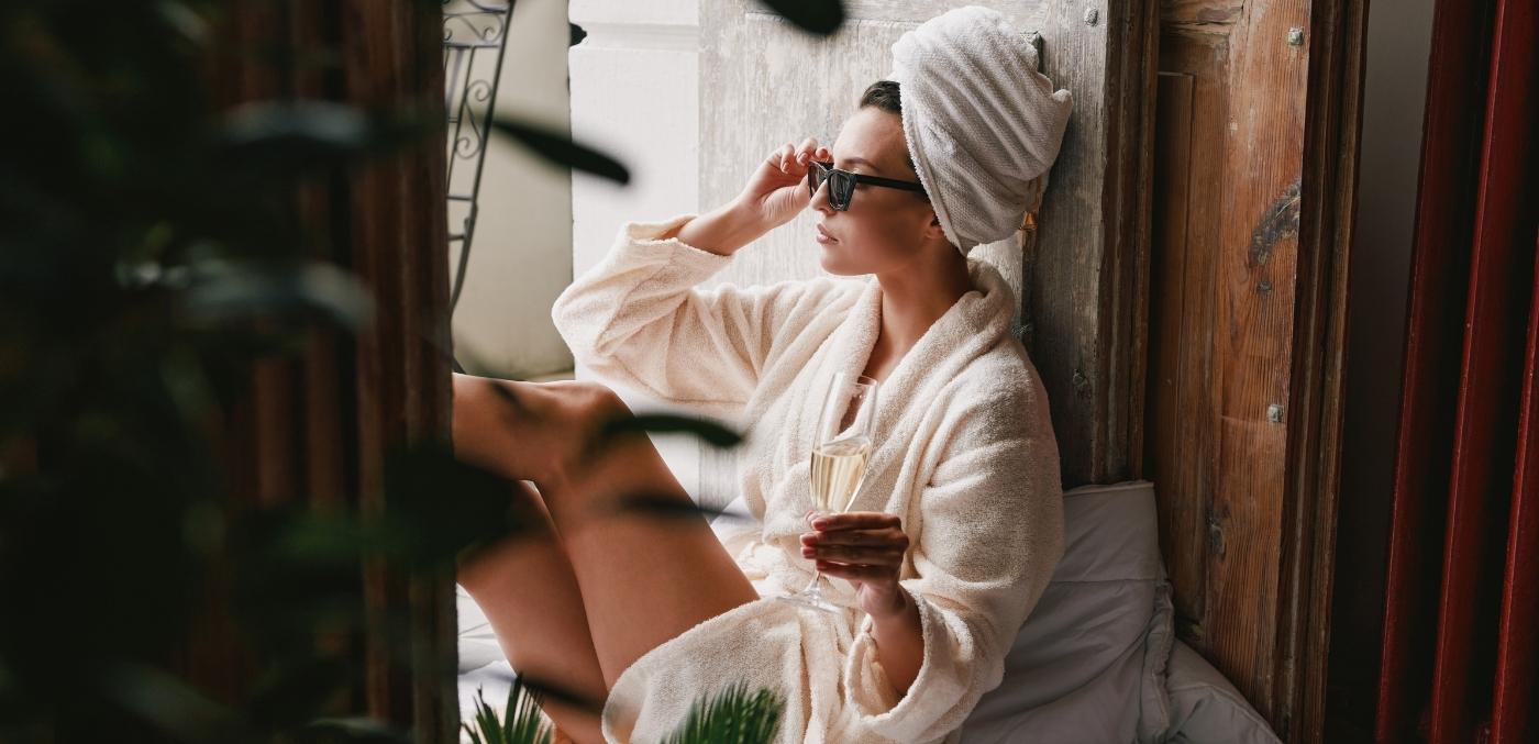 woman drinking champagne in a robe